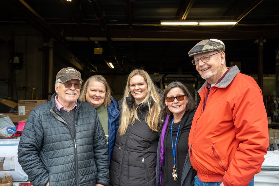 A group of people smile outside